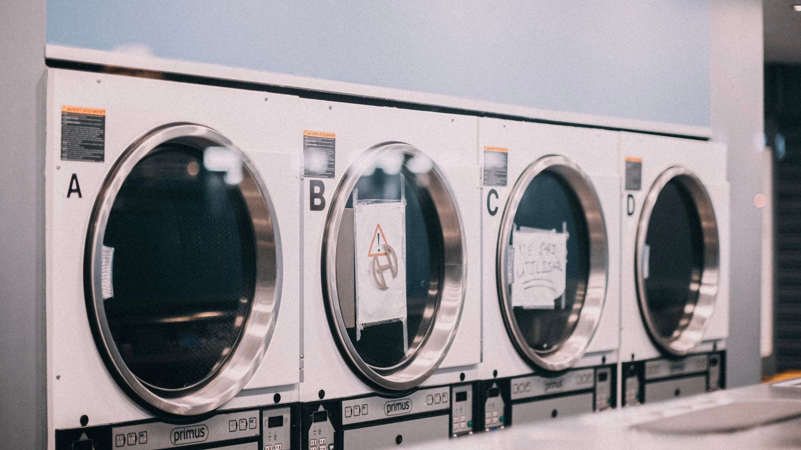 A row of large washing machines in a laundry