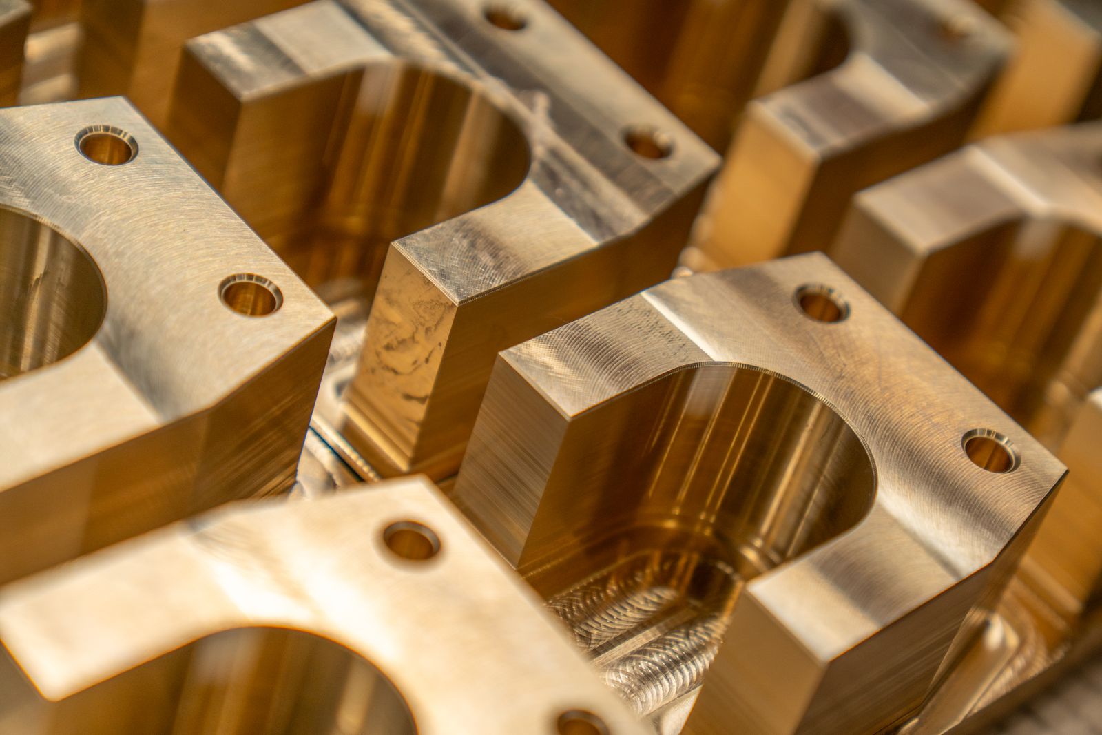 Machined brass components with bored holes, lined up close together