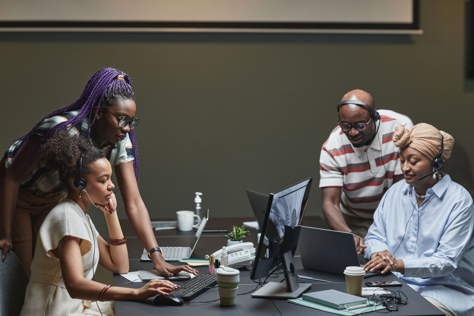 Three engineers looking at one screen together in an open office