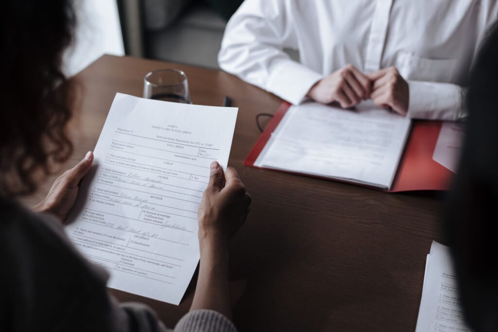 Two people going through printed documents at a table