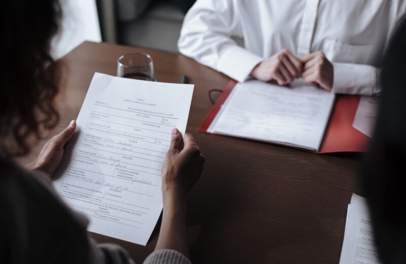 Two people going through printed documents at a table