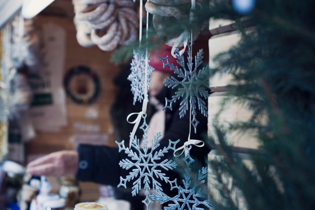 Glass snowflake ornaments hanging at an outdoor market stall