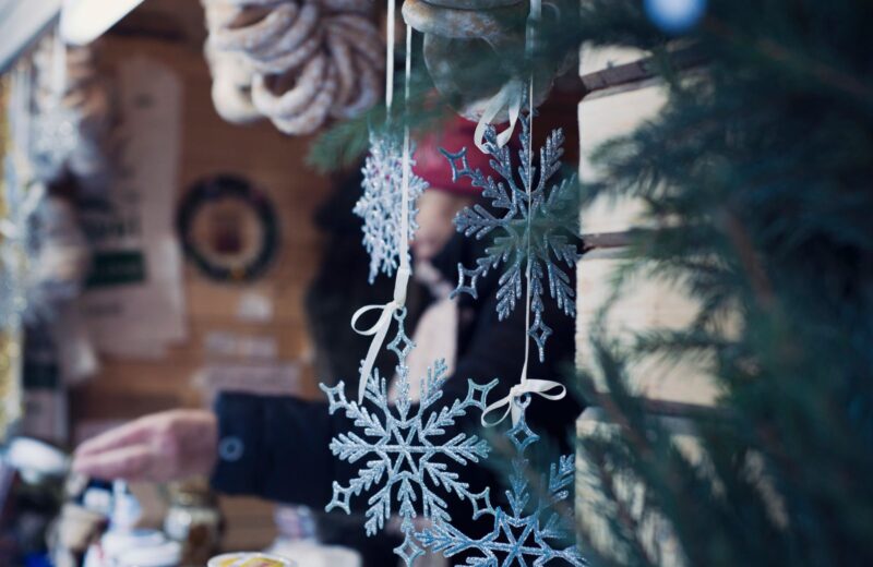 Glass snowflake ornaments hanging at an outdoor market stall