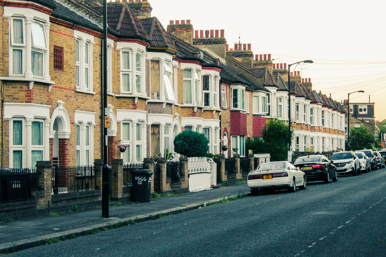 Terraced houses and parked cars along a quiet street at dusk