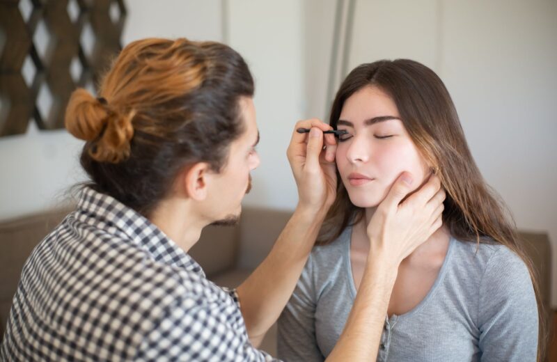 An artist fills in a client's brows with a fine brush