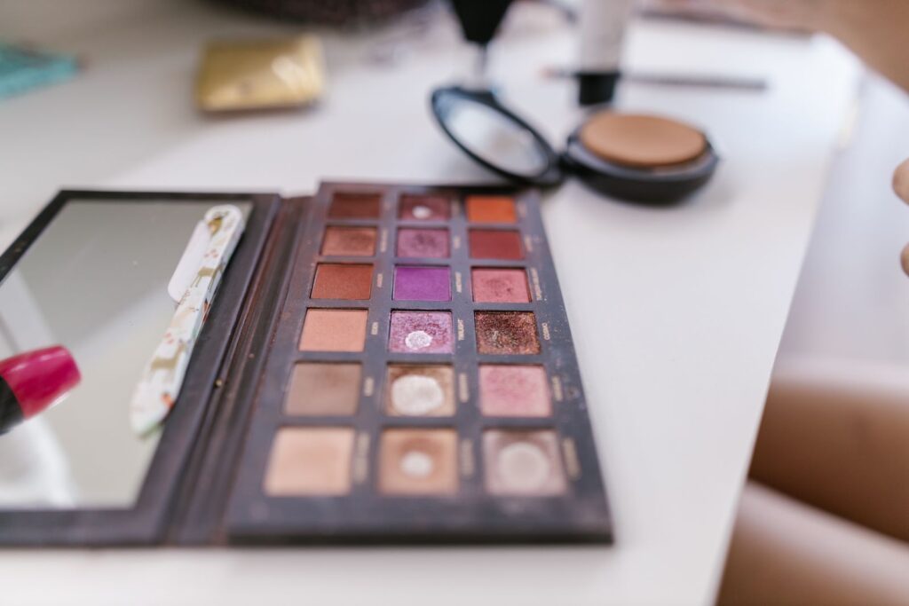 A well-used eyeshadow palette open on a white table