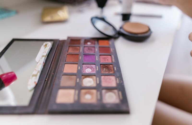 A well-used eyeshadow palette open on a white table