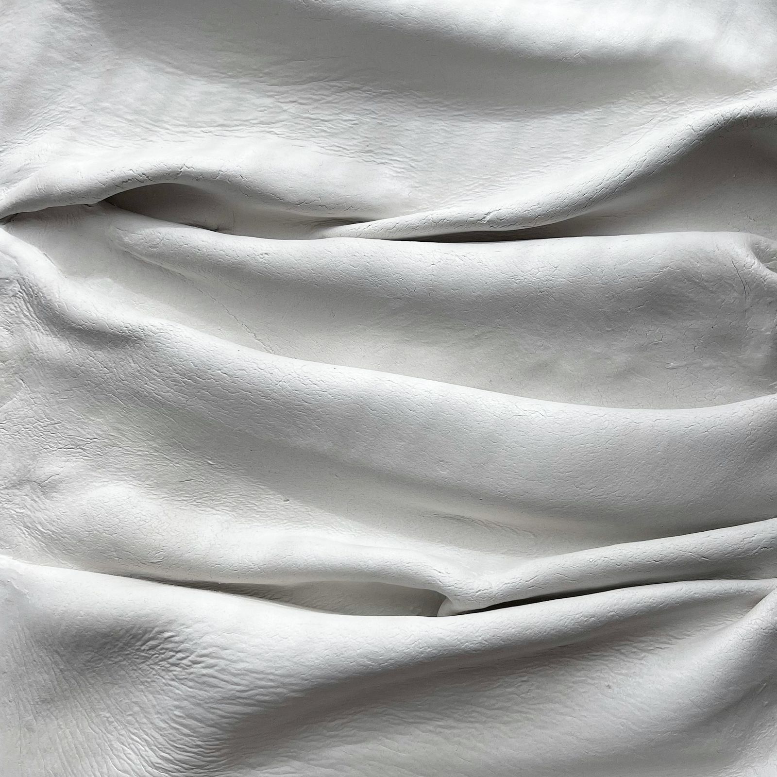 Soft folds of white cotton bed linen