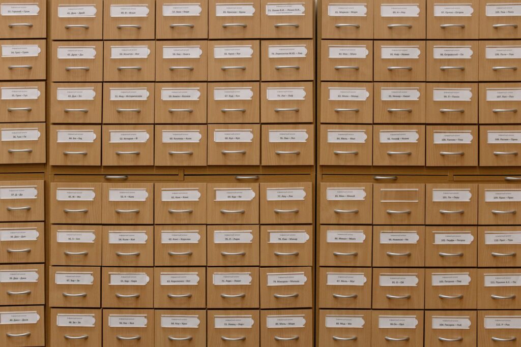 Rows of wooden archive drawers with paper labels