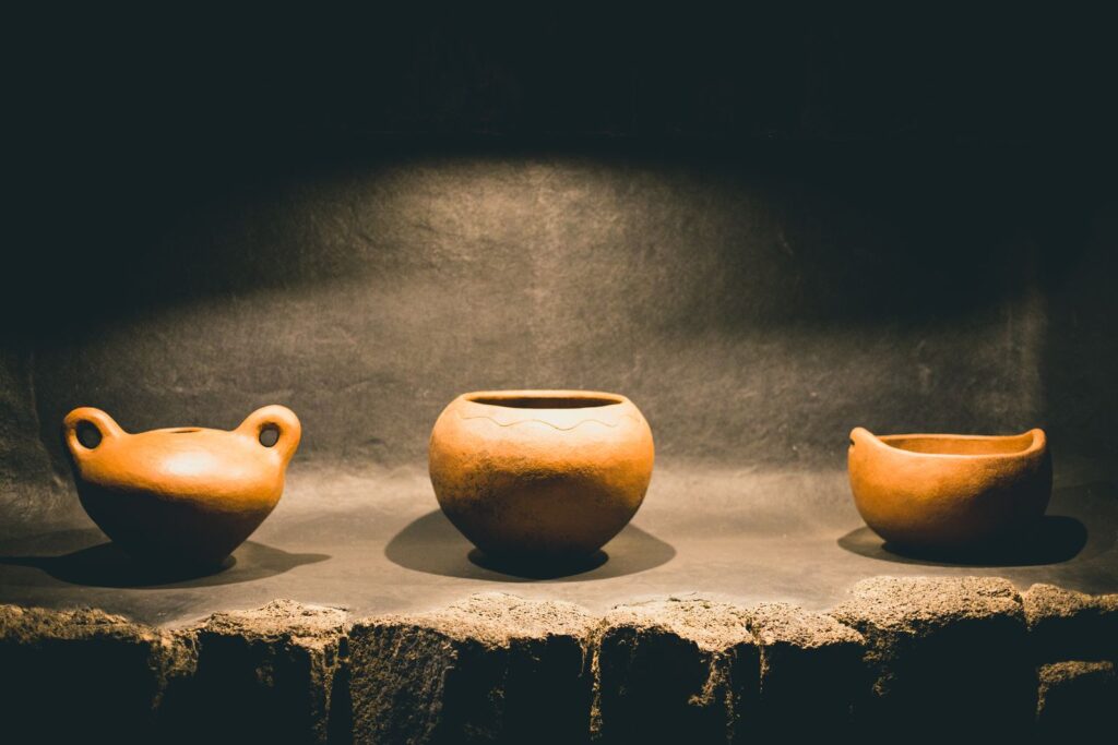 Three small clay bowls on a stone plinth