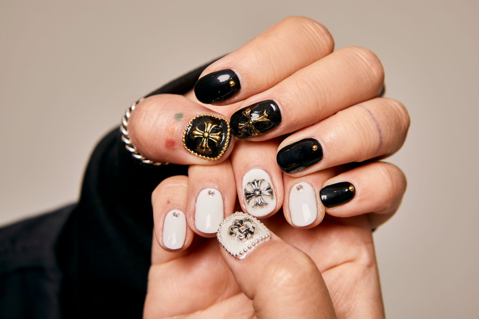 Hands with black and white nail art and small jewelled details