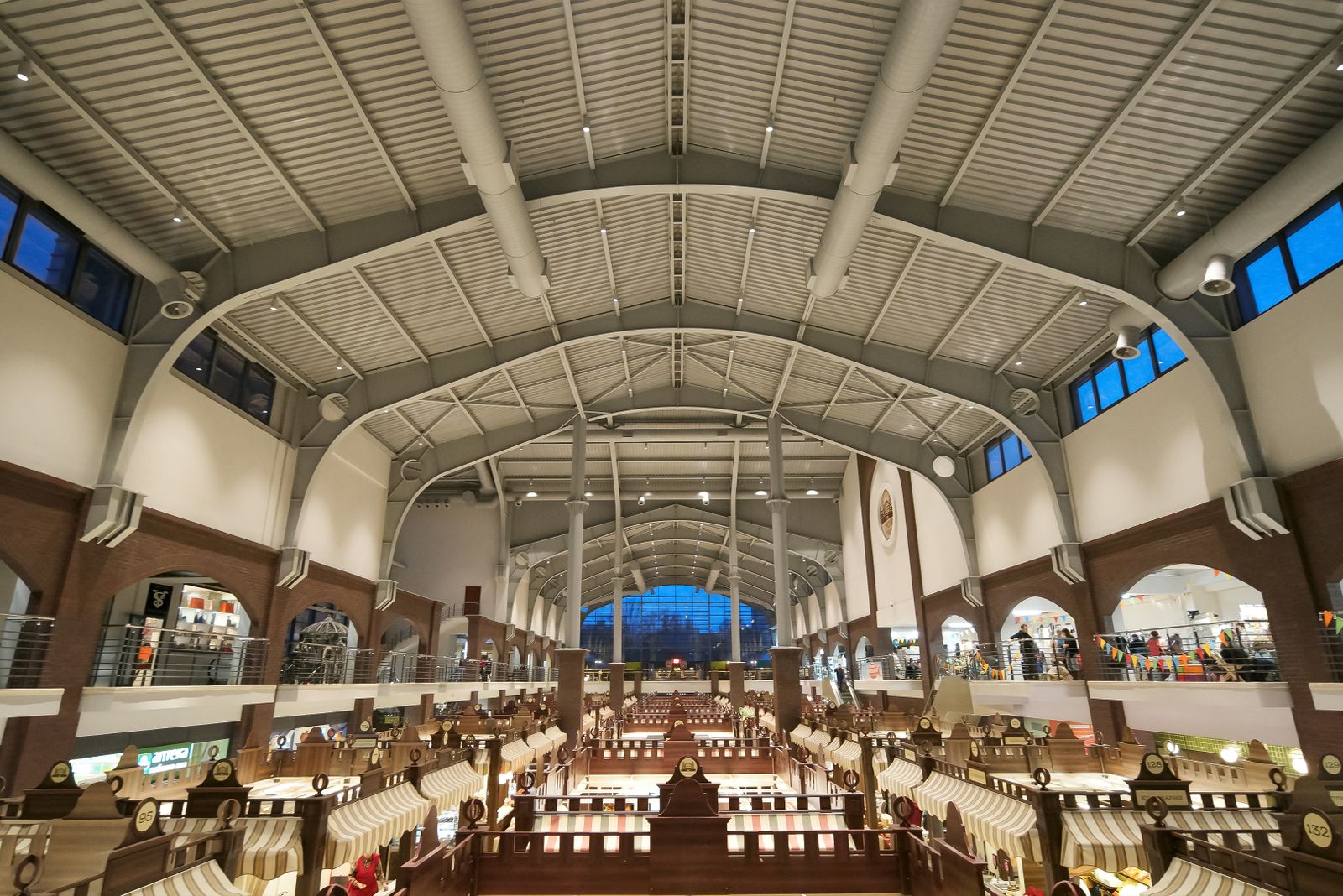 A large indoor market hall with rows of stalls under an arched roof