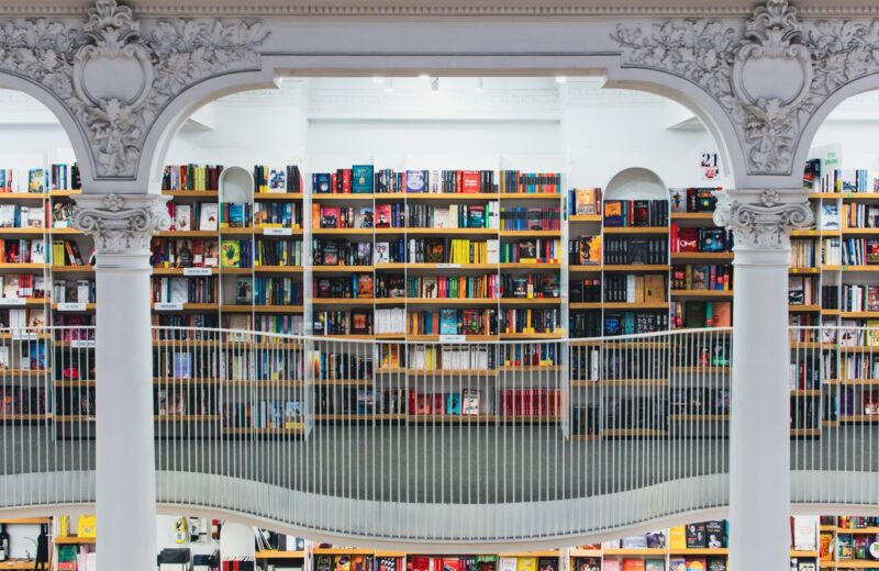 A library hall with tall bookshelves behind white columns
