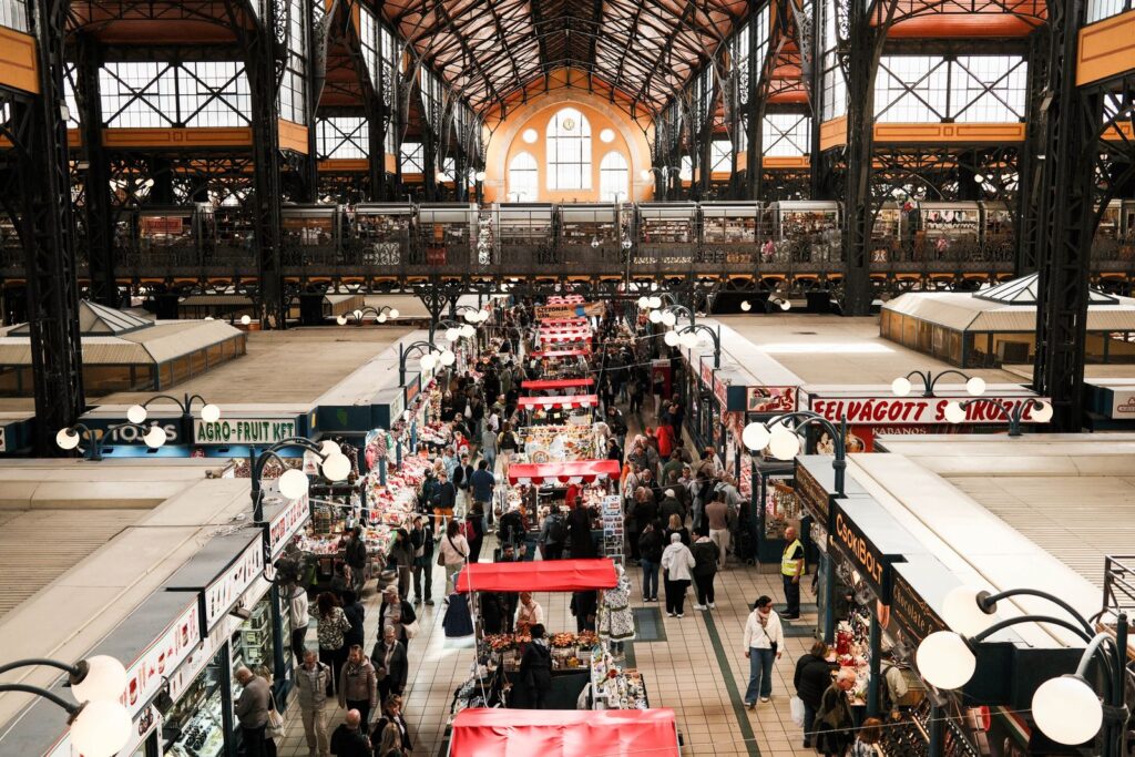 A market hall seen from the gallery, shoppers between the stalls