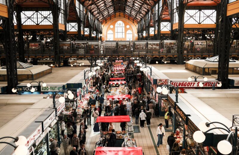A market hall seen from the gallery, shoppers between the stalls