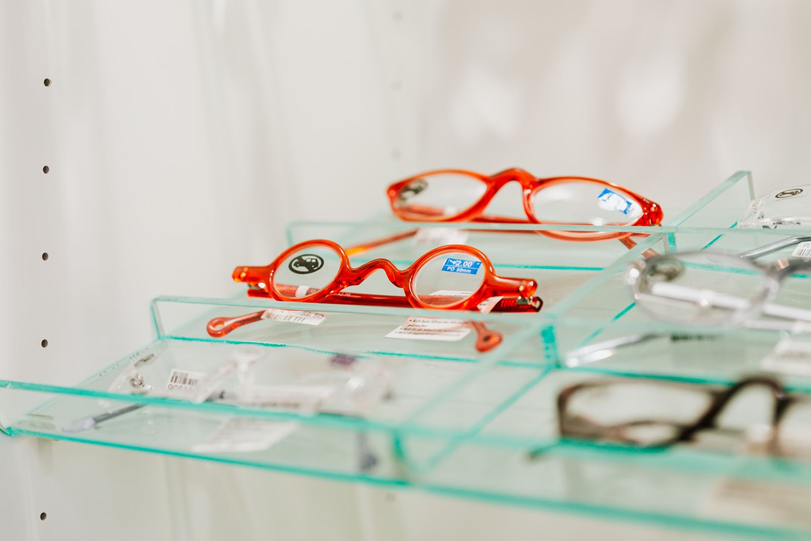 Small orange and red children's frames on a glass shelf