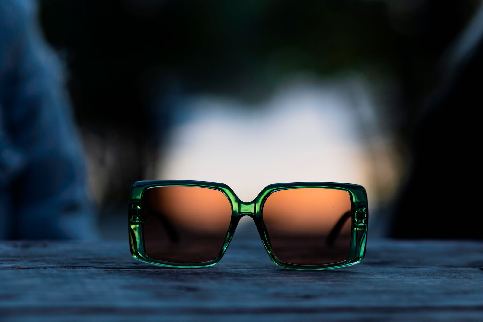 Green acetate sunglasses with brown lenses on a wooden table