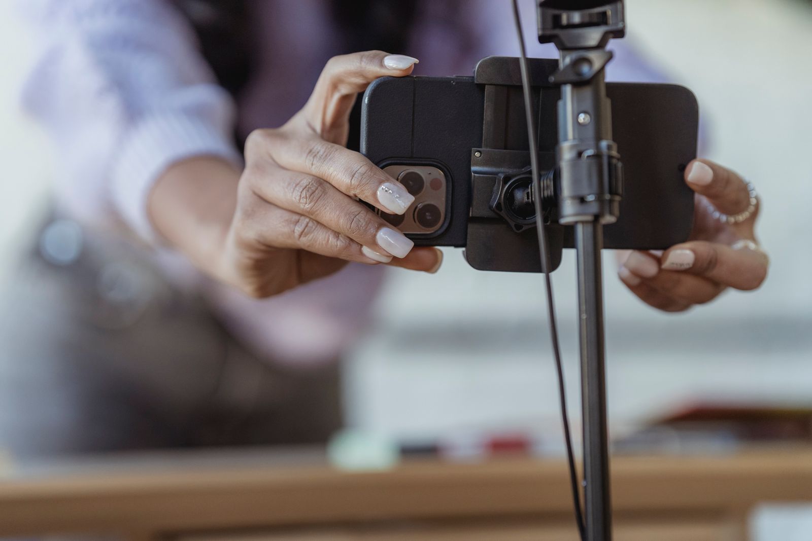 Hands fixing a phone into a tripod mount before filming
