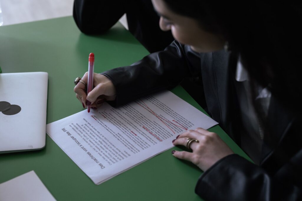 Marking up a printed draft with a red pen