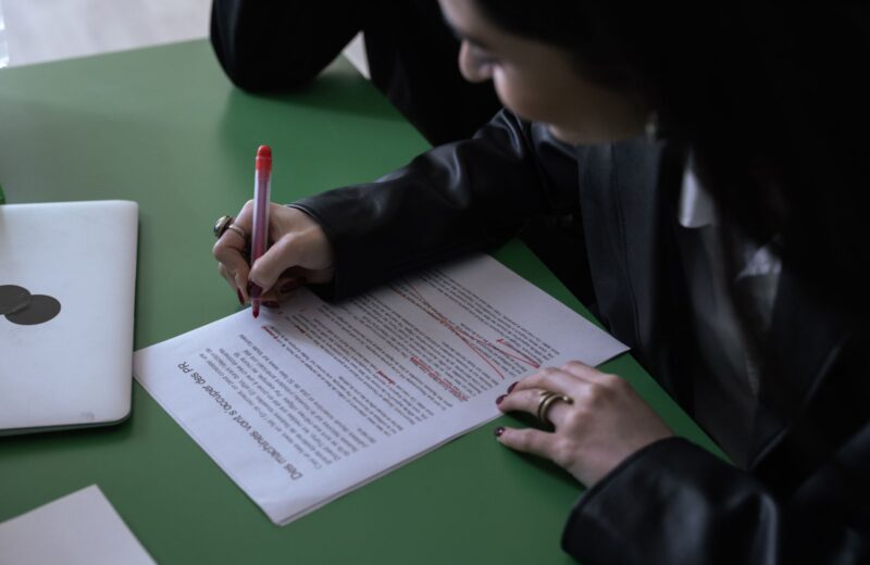 Marking up a printed draft with a red pen