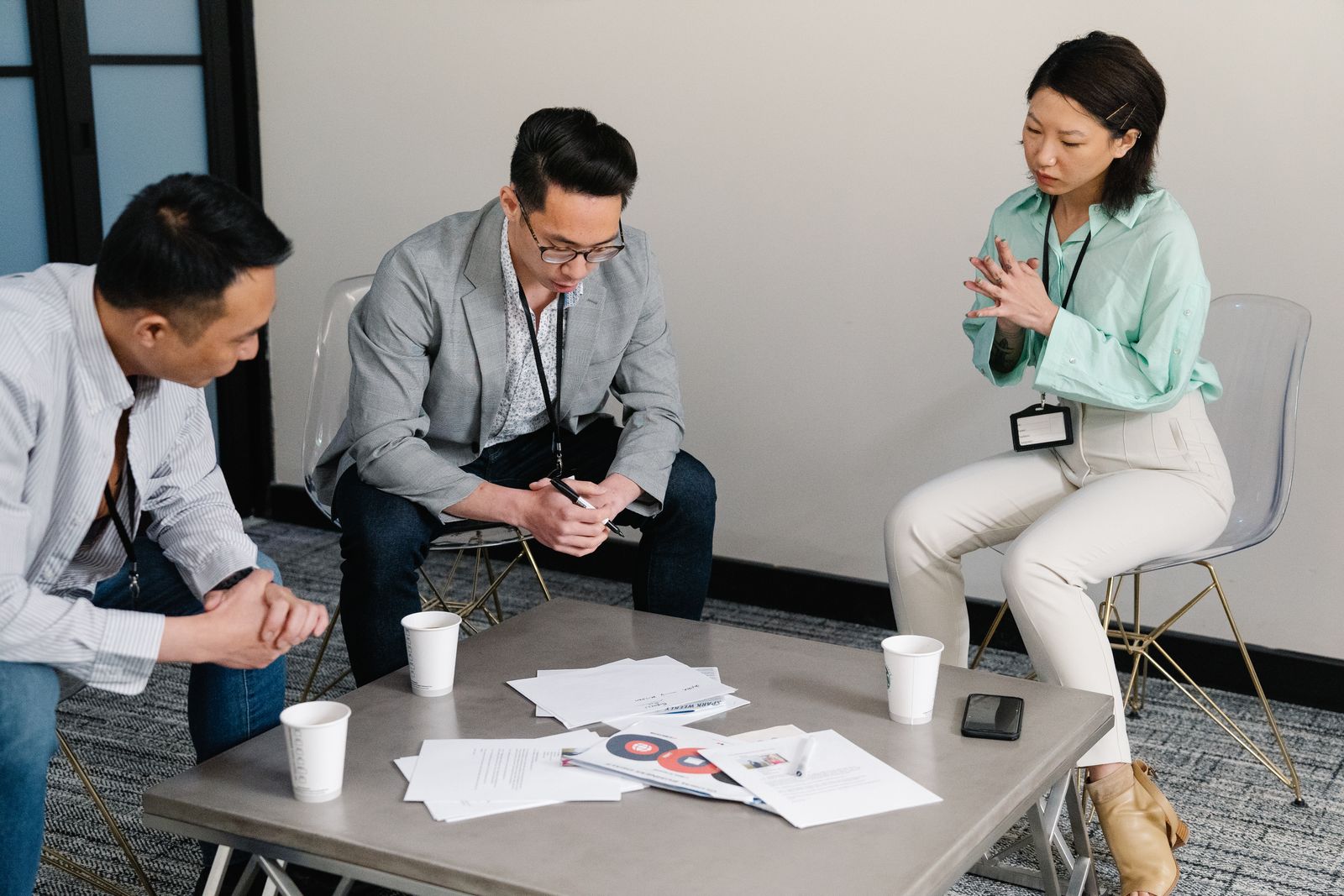 Four colleagues talking around a low table with printed notes