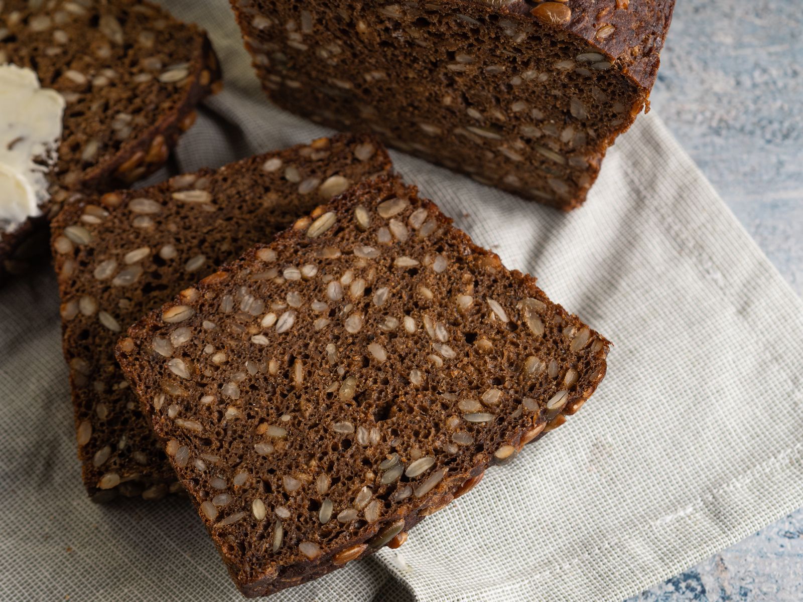 Slices of dark seeded rye bread on a linen cloth