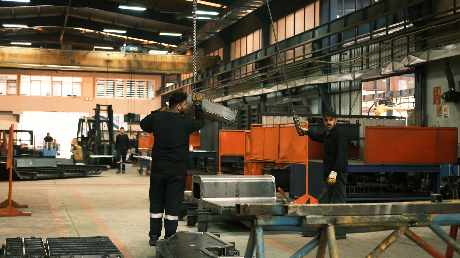 Workers operating machinery on a large factory floor