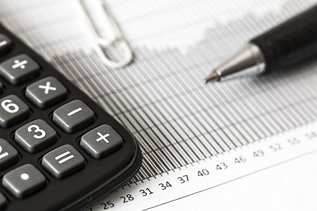 A calculator and a pen resting on a printed bar chart