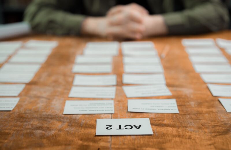 Index cards laid out in rows on a table to plan the order of scenes
