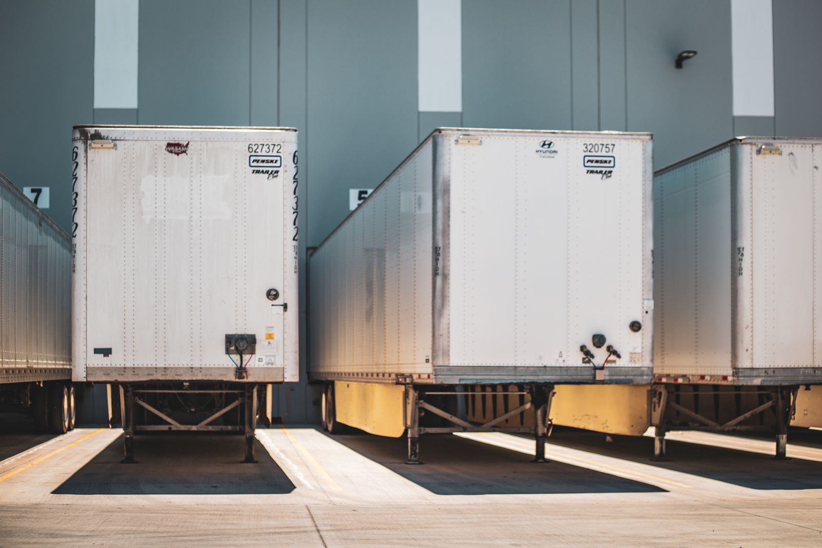 White freight trailers backed onto the doors of a loading dock