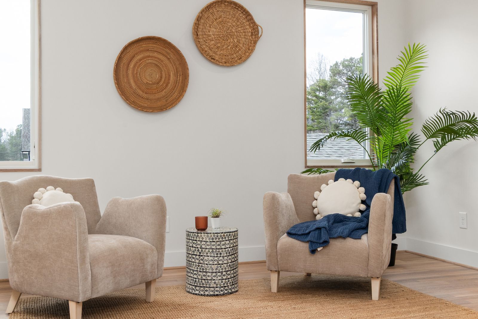 A quiet room with two armchairs facing each other, a small side table and a large plant
