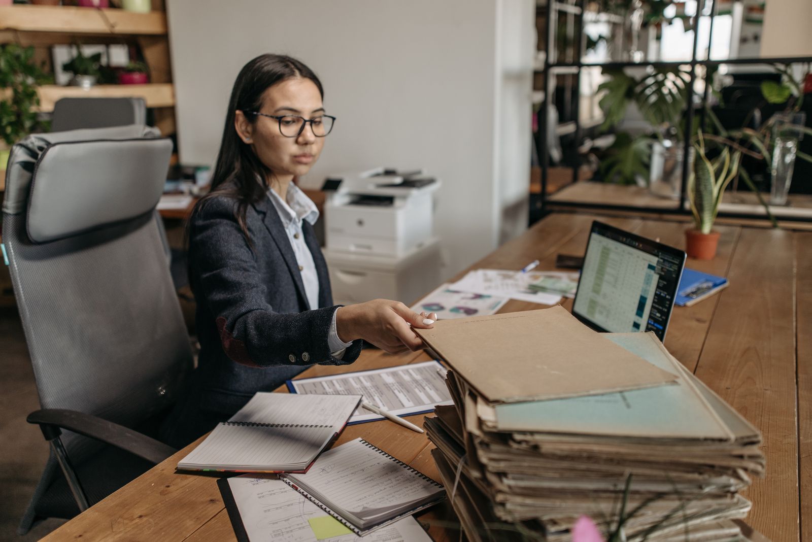 An office administrator working through folders at her desk