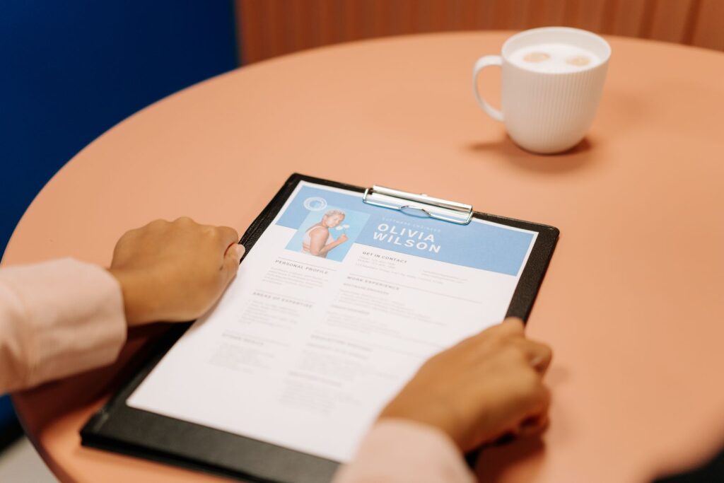 Hands holding a CV on a clipboard during an interview