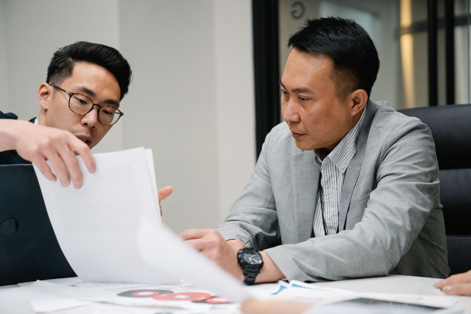 Two colleagues going through printed pages together at an office desk