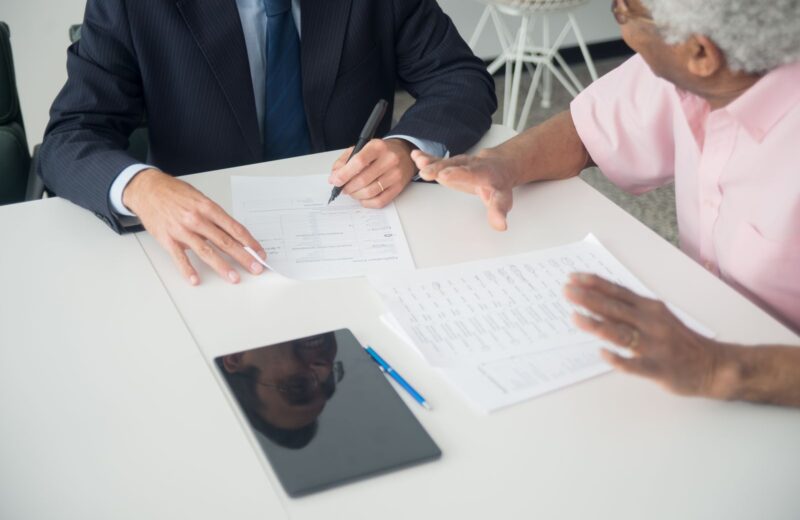 Two people going through printed schedules across a white table