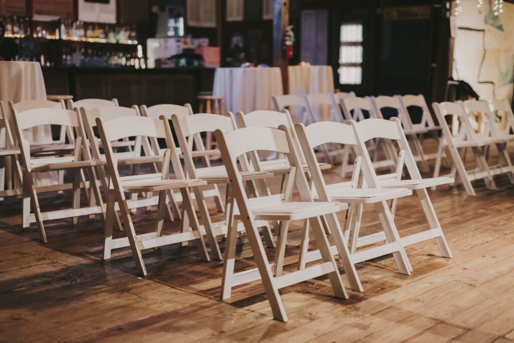 White folding chairs set out in rows in a hall