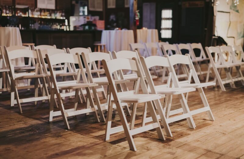 White folding chairs set out in rows in a hall
