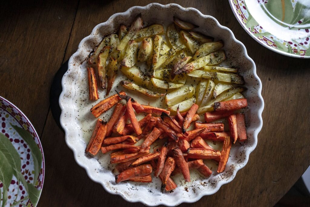 Roast potatoes and carrots with herbs on a plate