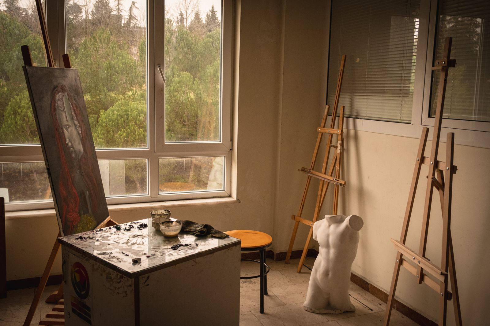 Art room with easels, a plaster bust and paints by the window