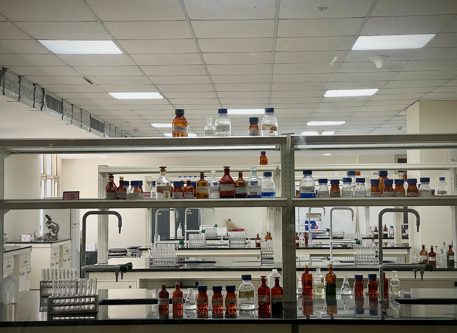 Science laboratory with benches, glassware and chemical bottles