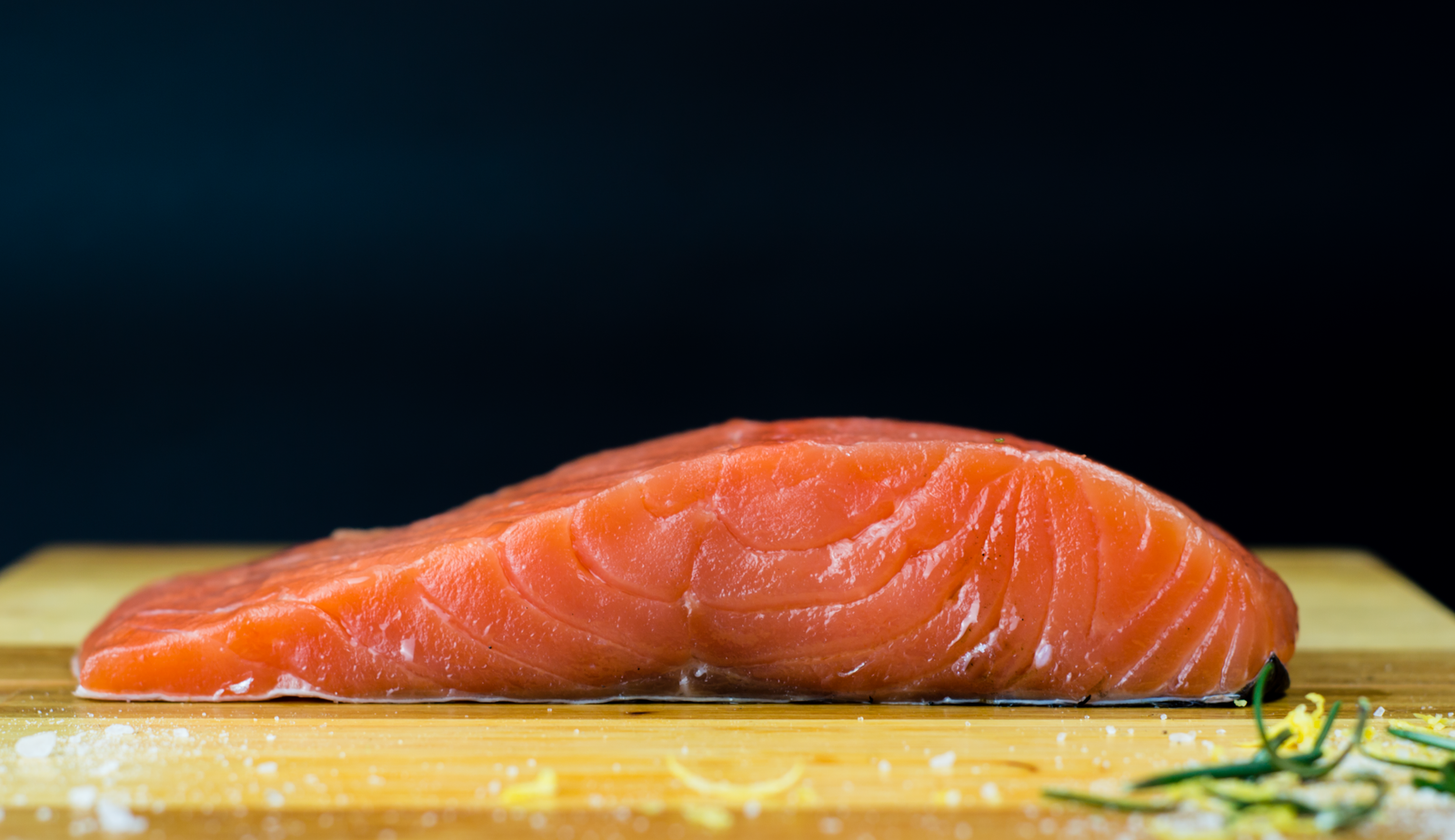 A thick fresh salmon fillet on a wooden board