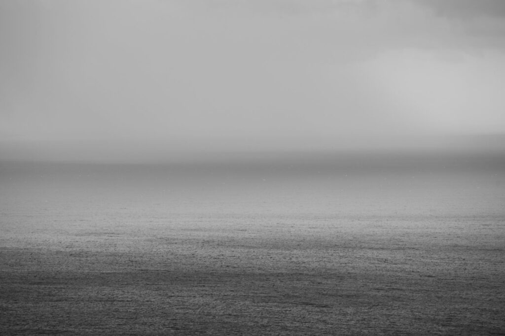 A calm sea and horizon in soft black and white