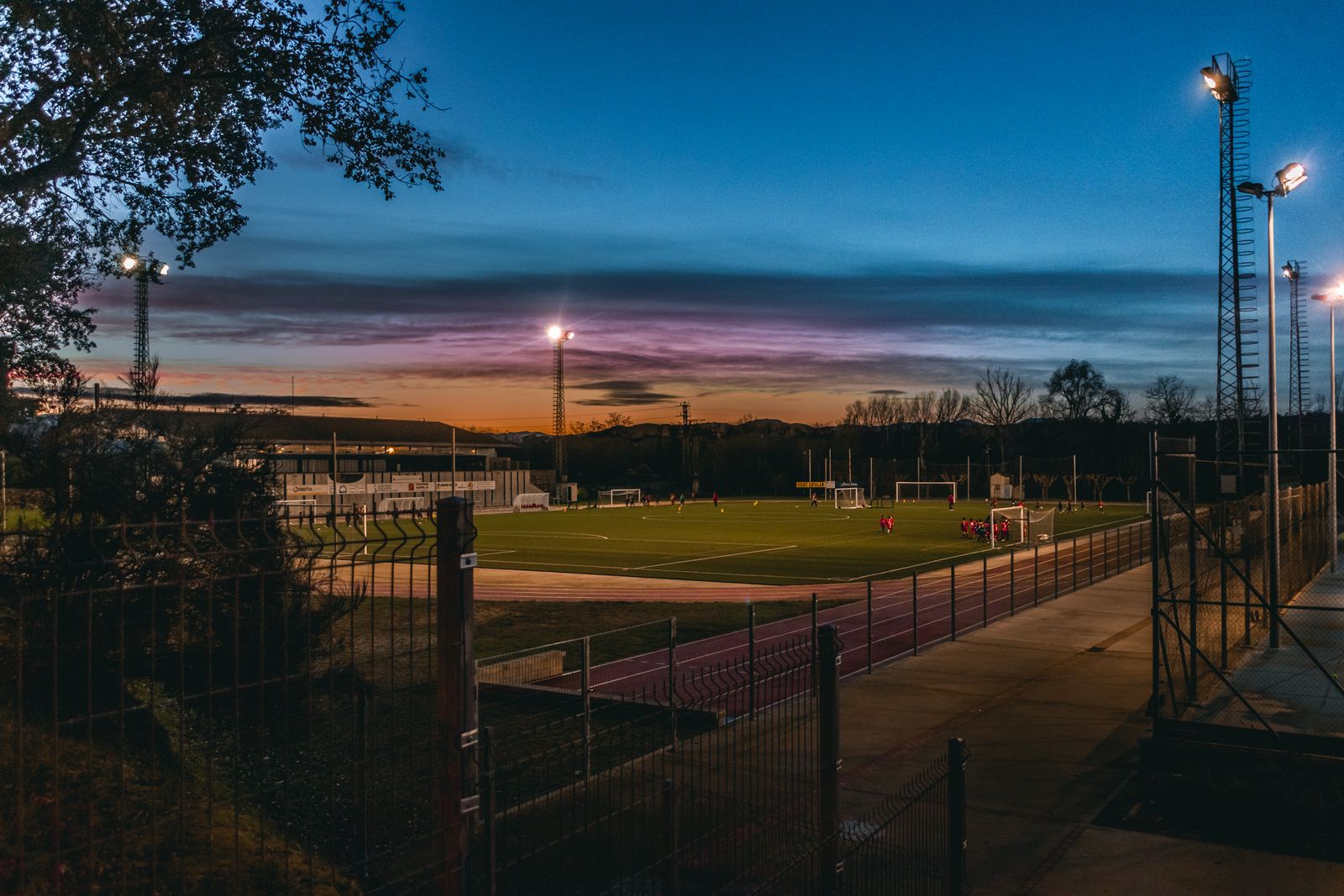 Floodlights over a football pitch at dusk