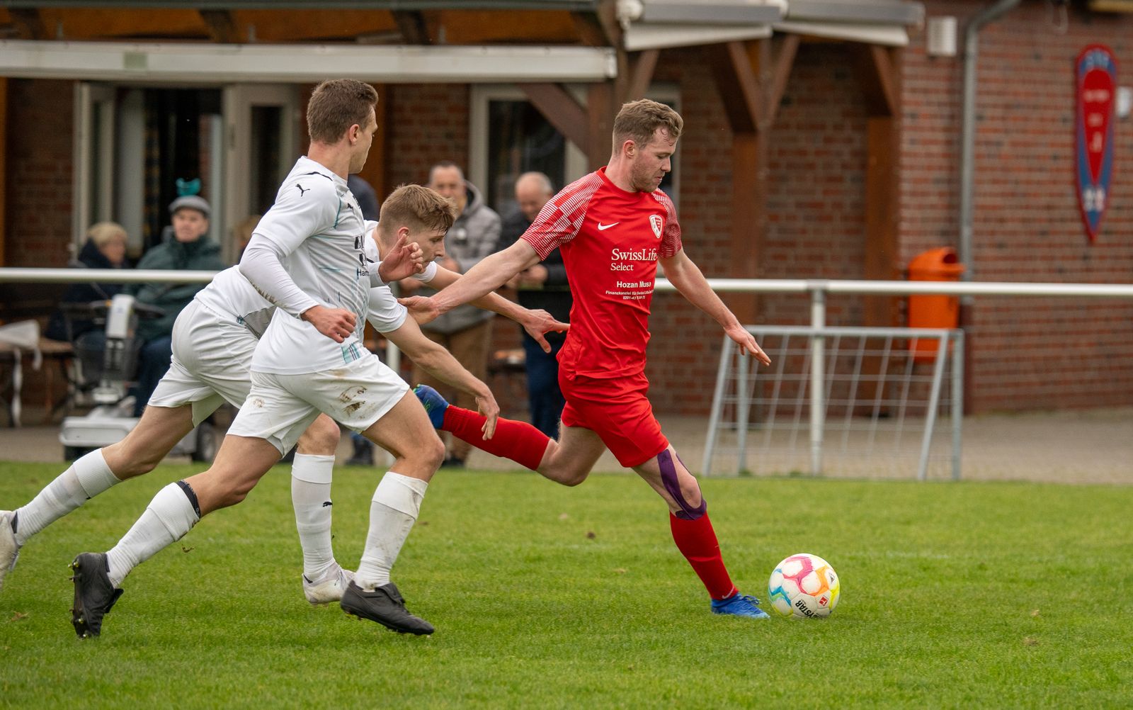 Players challenging for the ball in an amateur match