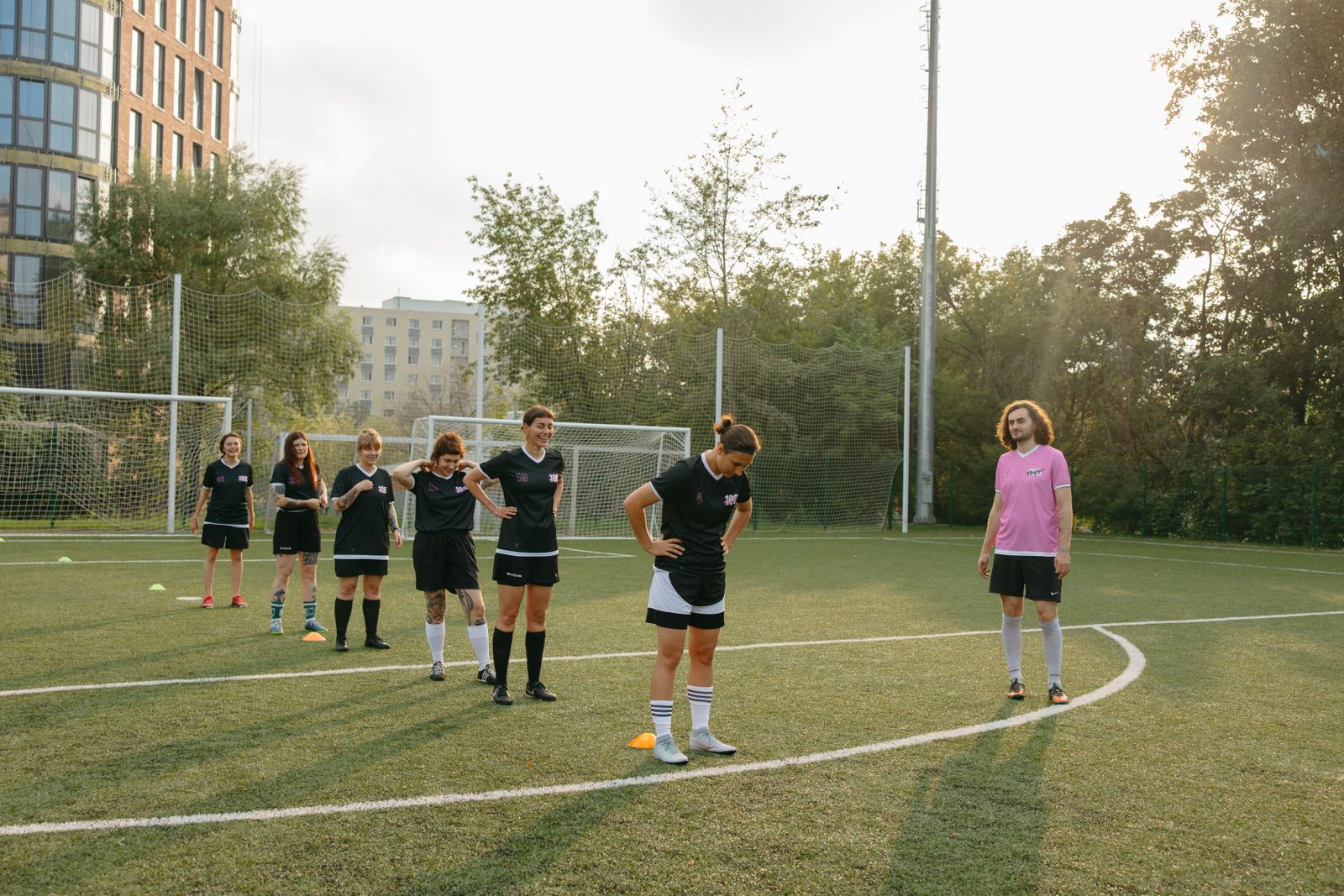 Women's team running drills while the coach watches