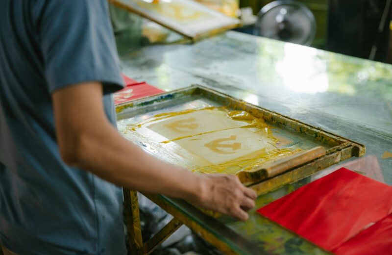 A screen-printing frame with a fresh print on the bench