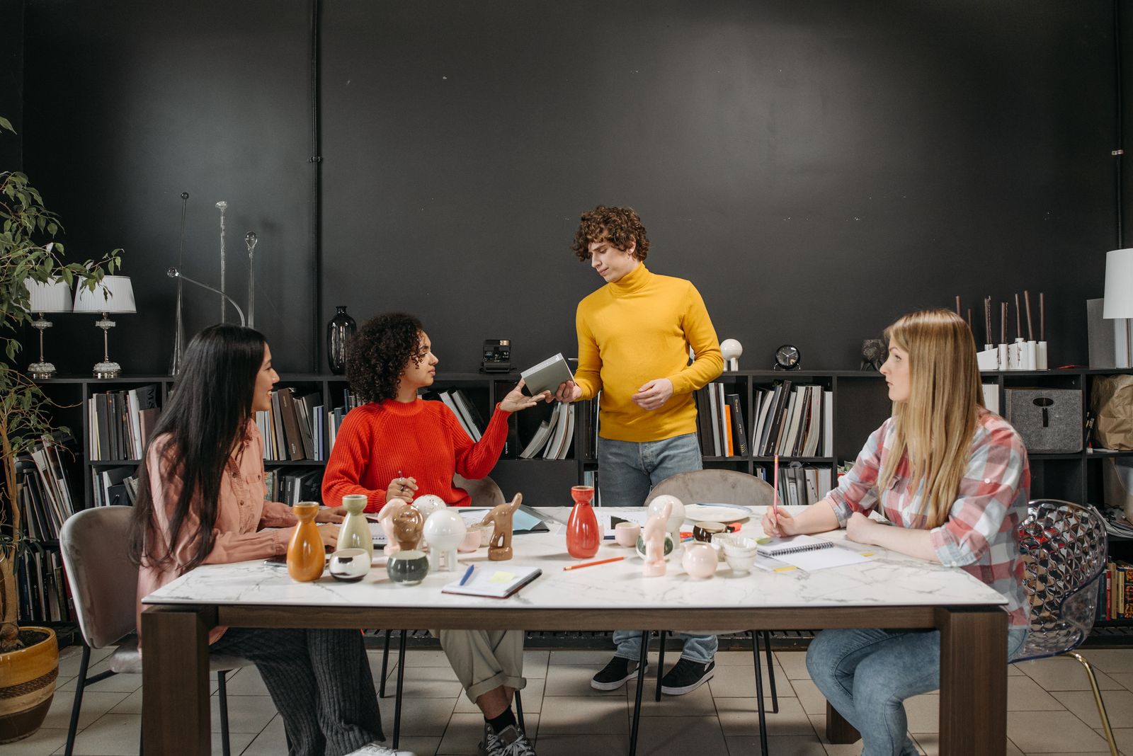 A small group working through materials at a long table in a workshop