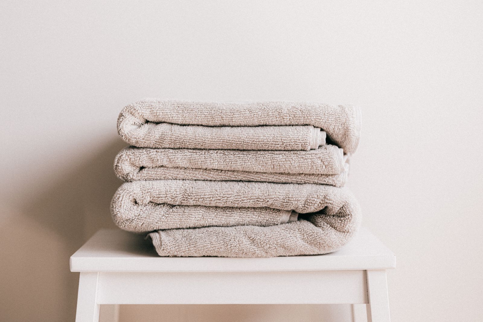 Clean folded towels stacked on a small white stool