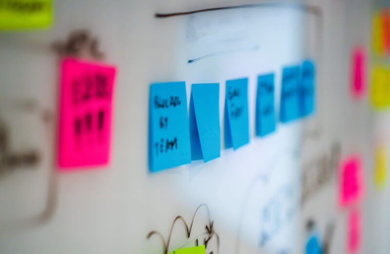 Sticky notes in pink, blue and yellow on a whiteboard