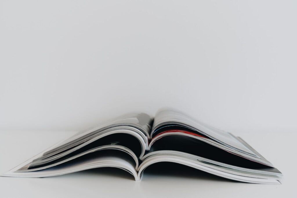 An open printed magazine lying on a white table